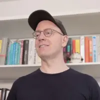 A photo of Colin O'Brien, standing in front of a bookshelf